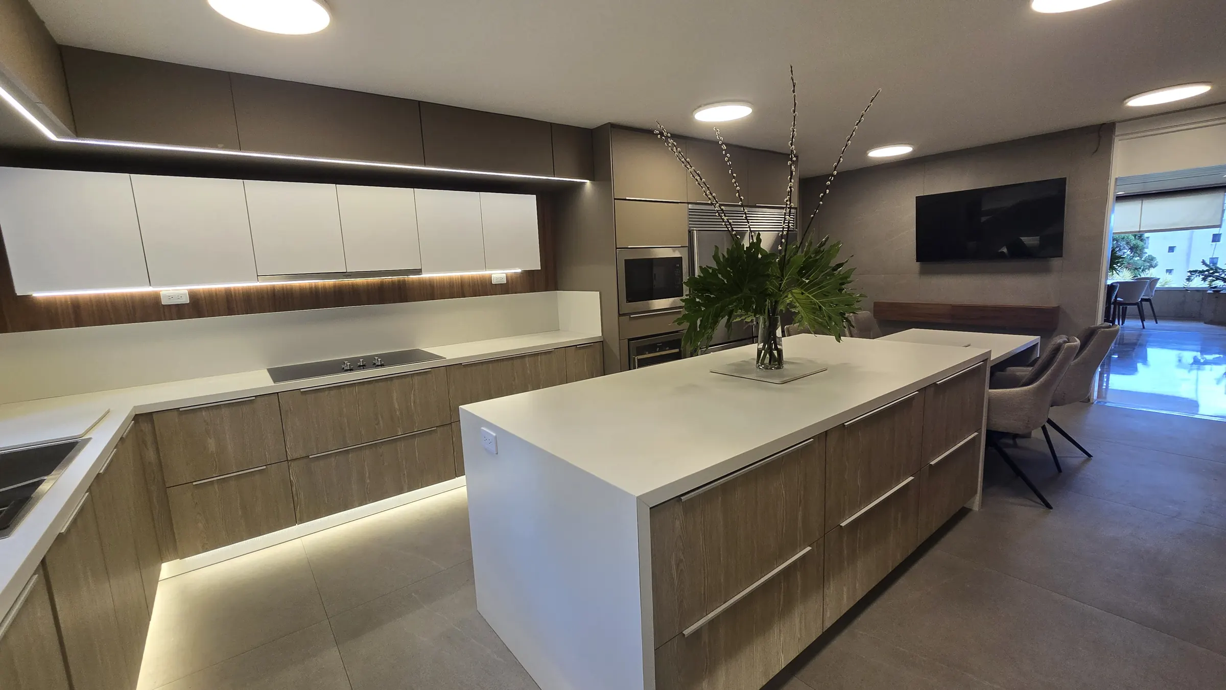 Cocina remodelada por el equipo de Oscar, con isla y luz bajo los muebles